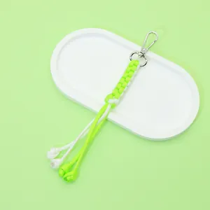 Detail of handmade neon green and white paracord keychain with silver metal clasp