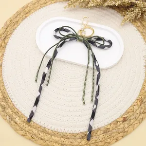 Eleganter Schlüsselanhänger mit Gingham-Schleife und funkelnden goldenen Strasssteinen