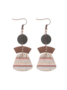 Detailed view of bohemian geometric earrings with multi-layered wood and cork texture