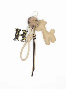 Primo piano del portachiavi con lettera H leopardata e giraffa beige in pelle PU per borsa