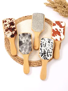 Detail view of bamboo hairbrushes with various cow print and animal patterns