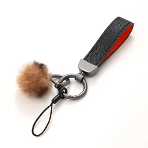 Hochwertiger Schlüsselanhänger aus Leder mit braunem Plüsch-Pompon und Metallteilen