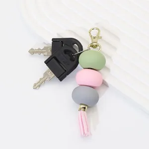 Detailed view of pastel macaron beads and pink tassel on a stylish golden keychain pendant