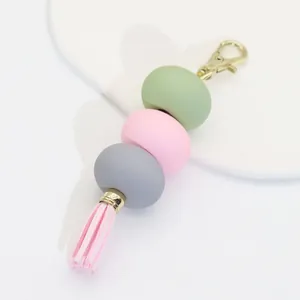 Macro view of macaron colored acrylic bead keychain with pink tassel detail