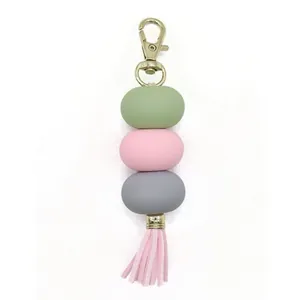 Macaron colored bead keychain featuring three pastel spheres and a pink decorative tassel