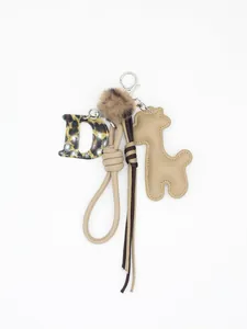 Dettaglio portachiavi con lettera D leopardata e ciondolo a giraffa in pelle PU