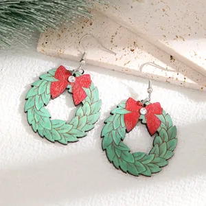Detailansicht süßer hölzerner Weihnachtskranz-Ohrringe mit roten Schleifen und Glitzer.