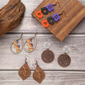 Close-up of assorted Halloween wooden earrings featuring pumpkin, candy corn and BOO designs