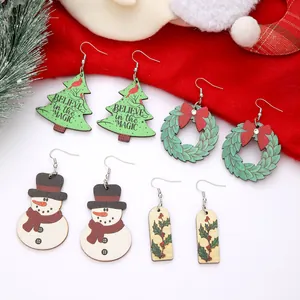 Nahaufnahme von hölzernen Weihnachtsohrringen mit Schneemännern und Bäumen.
