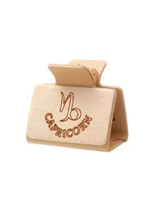 Detailopname van lasergegraveerd Steenbok-sterrenbeeld op beige haarklem van microvezel