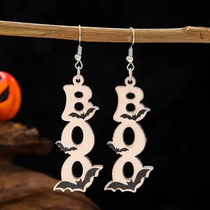 Handmade Halloween wooden bat BOO earrings hanging on a branch for holiday style