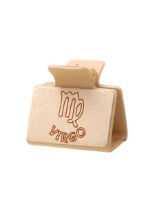 Detailweergave van lasergegraveerde Maagd-sterrenbeeld haarklem in beige