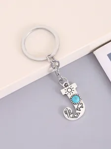 Close-up detail of silver alloy letter J keychain with turquoise and western motifs