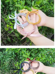 Close-up of flexible silicone gold foil jelly bangles tied with colorful ribbon bows