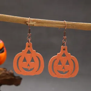 Detailed macro view of wooden orange Jack-o'-lantern earrings for Halloween style