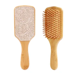 Detail view showing front embossed floral leather and back bristles of bamboo hairbrush.