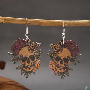Close-up detail of Halloween wooden skull earrings with floral and butterfly patterns