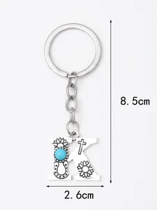 Detailed view of silver letter K keychain with turquoise stone and cross engraving