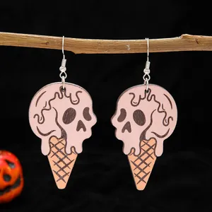 Close-up of wooden Halloween earrings featuring a pink skull ice cream cone design.