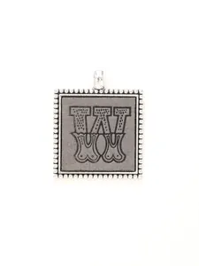 Close-up of vintage alloy square pendant featuring an ornate engraved letter W