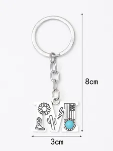 Close-up of letter M alloy keychain with turquoise stone and western engraved motifs
