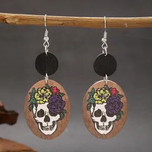 Detailed view of handmade wooden skull earrings featuring a vibrant floral crown design