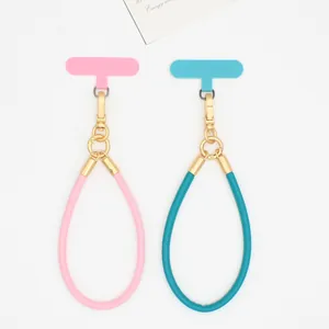 Detailed shot of pink and teal PU leather phone lanyard wrist straps with gold hardware