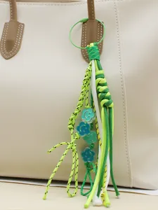Handgefertigter grüner geflochtener Taschenanhänger mit süßen blauen Blumenperlen
