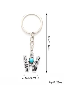 Close-up view of vintage silver letter W keychain with turquoise stone and engravings