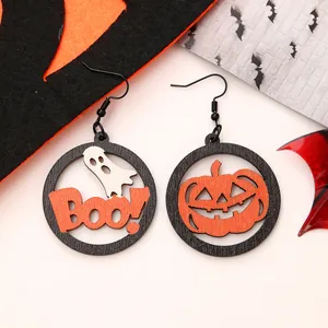 Close-up of Halloween wooden earrings with pumpkin and ghost design in orange and black