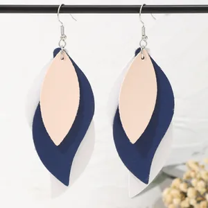 Detail view of multi-layered PU leather leaf earrings in navy and white