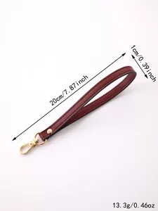 Detail showing dimensions of burgundy faux leather wristlet strap with gold clasp