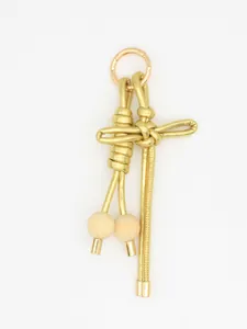 Detalle de un amuleto de nudo chino de cuero PU dorado con cuentas de madera