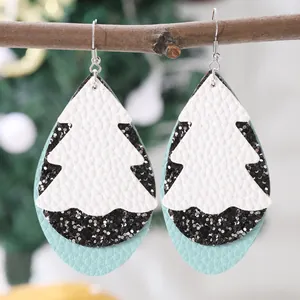 Detailaufnahme der Tropfen-Lederohrringe mit weißem Weihnachtsbaum-Design im Schicht-Look