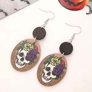 Macro detail of wooden Halloween earrings featuring colorful floral skull prints