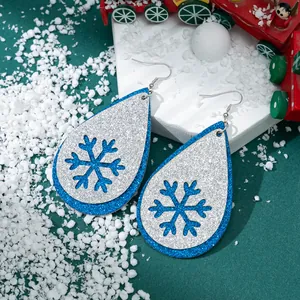 Blaue und silberne Glitzerleder-Ohrringe mit Schneeflockenausschnitten für Weihnachten.