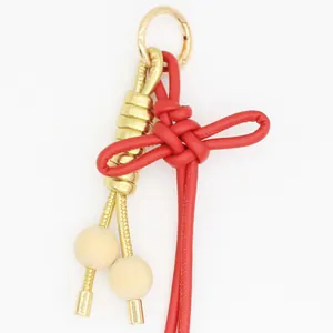 Llavero de nudo chino en cuero PU rojo con cierre dorado y cuentas para decoración de bolsos