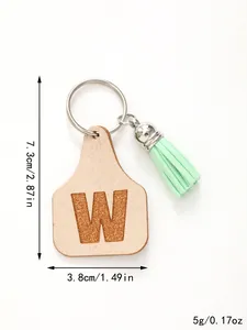 Detailed view of ear tag keychain with letter W and green tassel, dimensions included