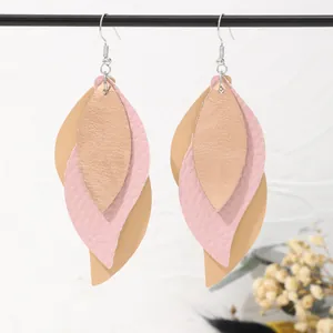 Detailed view of handmade multi-layered leaf-shaped PU leather earrings in soft pink and beige