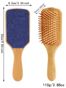 Detailed view of a bamboo hairbrush with dimensions 25cm by 8.5cm and blue floral pattern.
