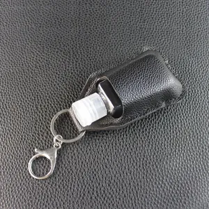 Black textured leather hand sanitizer holder keychain with an empty refillable bottle