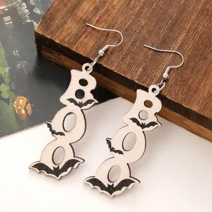 Detail shot of wooden Halloween earrings featuring BOO text and black bat designs.
