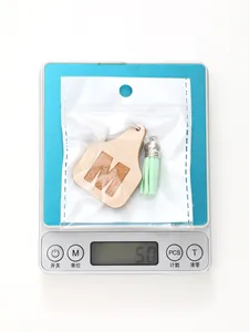 Detail view showing the 5.0g weight of the simple green tassel M letter keychain