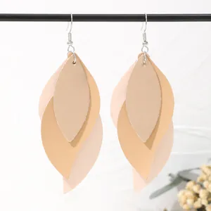 Close-up detail of bohemian multi-layer leaf-shaped PU leather drop earrings in beige tones.