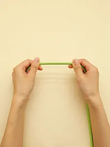 Detalle que muestra la resistencia y textura cosida de este cordón de cuero PU verde.