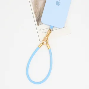 Close-up of light blue PU leather phone lanyard with gold metal hardware details