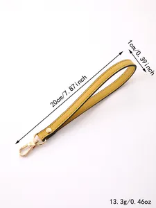 Detail view of yellow faux leather wristlet strap with gold clasp and dimensions