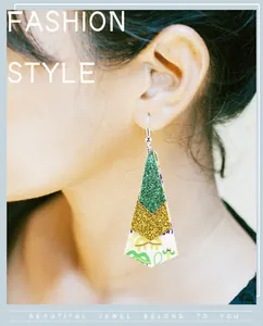 Close-up of three-layer Mardi Gras leather earrings with green and gold glitter finish