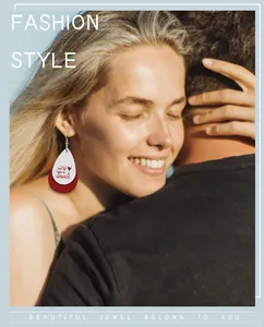 Close-up of stylish double-layered teardrop leather earrings worn by a model in outdoor light