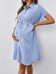 Side view detail of a light blue maternity shirt dress with an adjustable waist tie